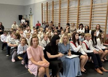 sala gimnastyczna, dzieci ubrane na galowo, dekoracja ślubowania, zaproszeni goście