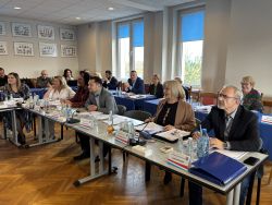 Radni siedzący przy stołach.