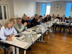 Radni siedzący przy stołach.