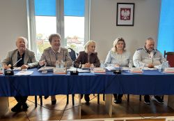 Radni siedzący przy stołach.