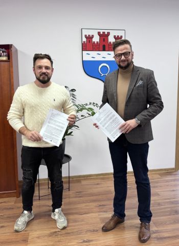 Burmistrz i wykonawca pozują do zdjęcia