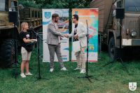 Dwóch mężczyzn patrzących na siebie ściska sobie prawe dłonie.