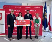 trzy osoby pozują do zdjęcia na tle biało-czerwonej ścianki z napisem mazowsze