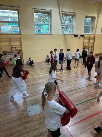 sale gimnastyczne w szkołach, ćwiczące dzieci, instruktorzy