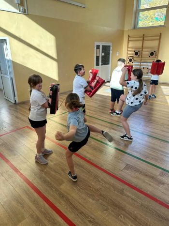 sale gimnastyczne w szkołach, ćwiczące dzieci, instruktorzy