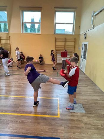 sale gimnastyczne w szkołach, ćwiczące dzieci, instruktorzy