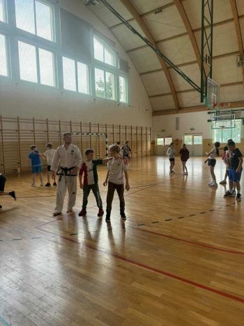 sale gimnastyczne w szkołach, ćwiczące dzieci, instruktorzy