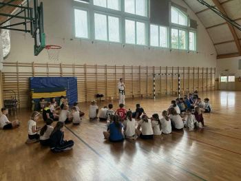 sale gimnastyczne w szkołach, ćwiczące dzieci, instruktorzy