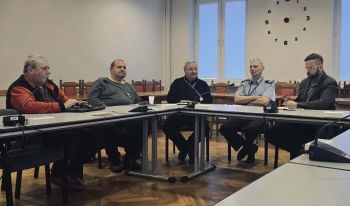 osoby siedzące przy stole konferencyjnym, sala konferencyjna