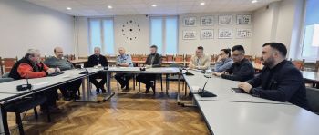 osoby siedzące przy stole konferencyjnym, sala konferencyjna