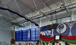 dzieci w kolorowych strojach, występy dzieci, hala sportowa, zaproszeni goście na trybunach