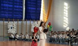 dzieci w kolorowych strojach, występy dzieci, hala sportowa, zaproszeni goście na trybunach