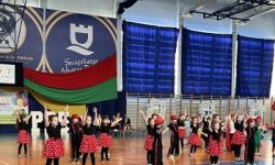 dzieci w kolorowych strojach, występy dzieci, hala sportowa, zaproszeni goście na trybunach