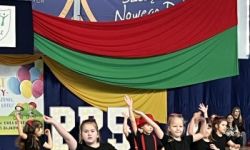 dzieci w kolorowych strojach, występy dzieci, hala sportowa, zaproszeni goście na trybunach