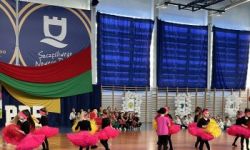 dzieci w kolorowych strojach, występy dzieci, hala sportowa, zaproszeni goście na trybunach