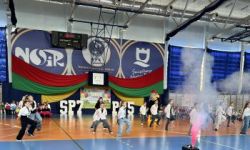 dzieci w kolorowych strojach, występy dzieci, hala sportowa, zaproszeni goście na trybunach