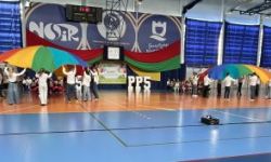 dzieci w kolorowych strojach, występy dzieci, hala sportowa, zaproszeni goście na trybunach