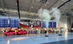 dzieci w kolorowych strojach, występy dzieci, hala sportowa, zaproszeni goście na trybunach