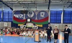 dzieci w kolorowych strojach, występy dzieci, hala sportowa, zaproszeni goście na trybunach