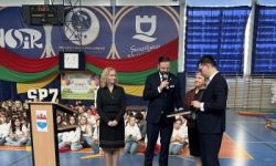 dzieci w kolorowych strojach, występy dzieci, hala sportowa, zaproszeni goście na trybunach