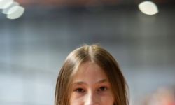 zawodniczka pozuje do zdjęcia ubrana w czerwoną bluzę, ręce ma złożone na piersiach