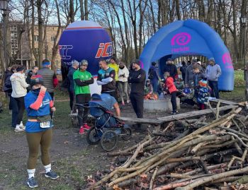 osoby stojące przy ognisku, w tle balon i brama promocyjna