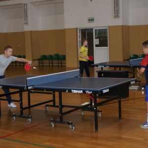 Dwóch chłopców grających w tenisa stołowego.