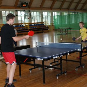 Dwóch chłopców grających w tenisa stołowego.