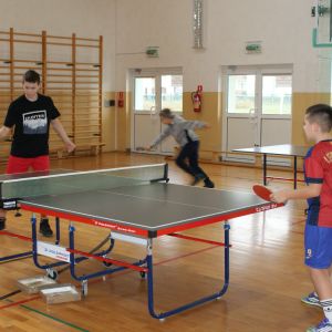 Dwóch chłopców grających w tenisa stołowego.