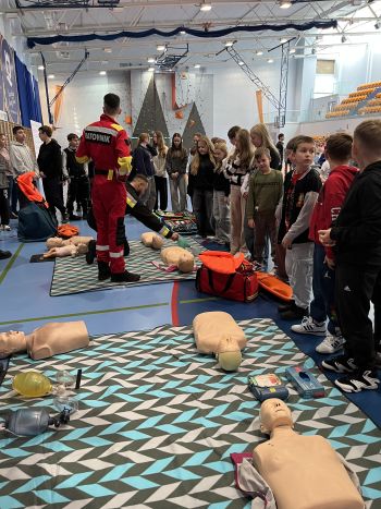 Hala sportowa, dzieci zebrane na hali, zajęcia sportowe oraz z udzielania pierwszej pomocy