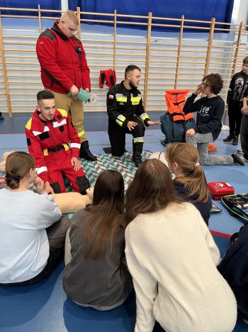 Hala sportowa, dzieci zebrane na hali, zajęcia sportowe oraz z udzielania pierwszej pomocy