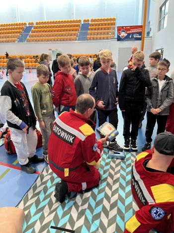 Hala sportowa, dzieci zebrane na hali, zajęcia sportowe oraz z udzielania pierwszej pomocy