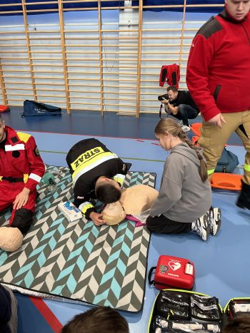 Hala sportowa, dzieci zebrane na hali, zajęcia sportowe oraz z udzielania pierwszej pomocy