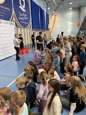 Hala sportowa, dzieci zebrane na hali, zajęcia sportowe oraz z udzielania pierwszej pomocy