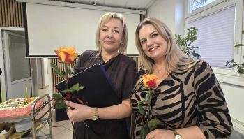 sala konferencyjna, na krzesłach siedzą zaproszeni pracownicy społeczni, rozdawanie kwiatów, zdjęcie wspólne