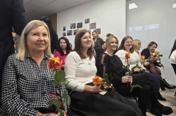 sala konferencyjna, na krzesłach siedzą zaproszeni pracownicy społeczni, rozdawanie kwiatów, zdjęcie wspólne