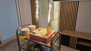 sala konferencyjna, na krzesłach siedzą zaproszeni pracownicy społeczni, rozdawanie kwiatów, zdjęcie wspólne