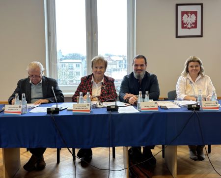 dwie kobiety i dwóch mężczyzn siedzą za stołem, uśmiechają się do obiektywu,