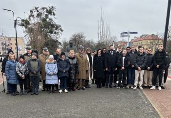 uroczystość pod pomnikiem, przemówienia, składanie kwiatów, poczty sztandarowe ze szkół