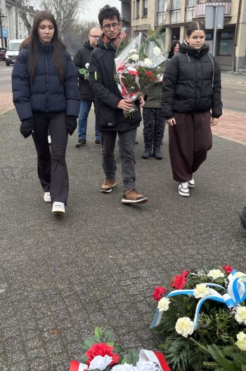 uroczystość pod pomnikiem, przemówienia, składanie kwiatów, poczty sztandarowe ze szkół