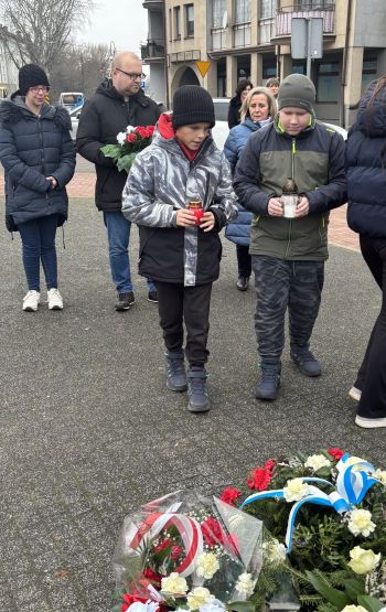 uroczystość pod pomnikiem, przemówienia, składanie kwiatów, poczty sztandarowe ze szkół