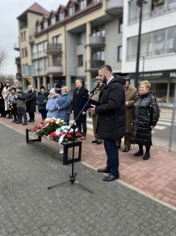 uroczystość pod pomnikiem, przemówienia, składanie kwiatów, poczty sztandarowe ze szkół