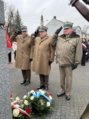 uroczystość pod pomnikiem, przemówienia, składanie kwiatów, poczty sztandarowe ze szkół