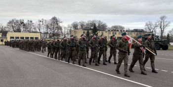 plac, żołnierze stojący na baczność, gratulacje dla bohatera, wręczanie kwiatów i pamiątkowej tabliczki
