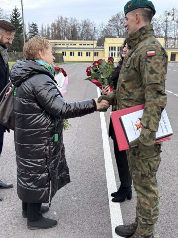 plac, żołnierze stojący na baczność, gratulacje dla bohatera, wręczanie kwiatów i pamiątkowej tabliczki