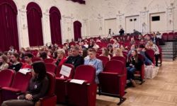 sala kinowa, zebrana młodzież, wręczanie nagród na scenie, prezentacja wyświetlana na ekranie