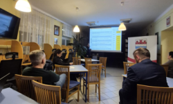 sala z dużym ekranem na którym wyświetlana jest prezentacja