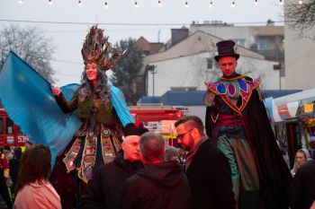 udekorowany skwer, scena, występy, osoby biorące udział w spotkaniu, poczęstunek, karuzela, żywa szopka