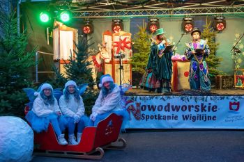 udekorowany skwer, scena, występy, osoby biorące udział w spotkaniu, poczęstunek, karuzela, żywa szopka