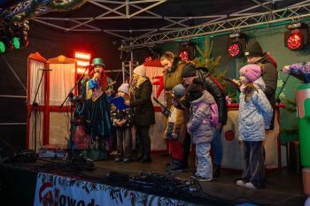 udekorowany skwer, scena, występy, osoby biorące udział w spotkaniu, poczęstunek, karuzela, żywa szopka